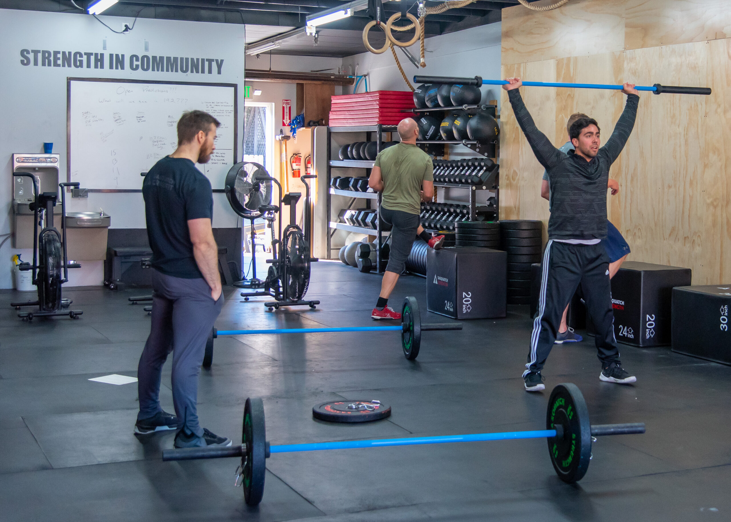 Members lifting barbells during a strength workout at Sasquatch Strength