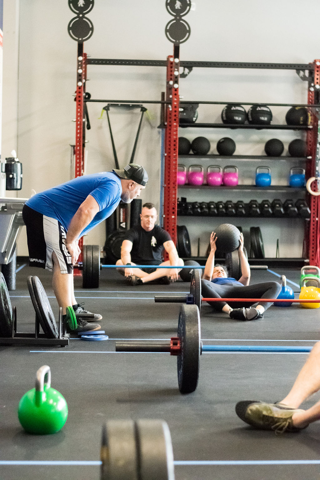 Man in a lifting belt training with weights in a coached gym session