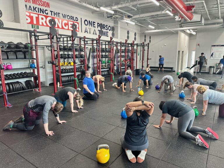 Group fitness class training together under the Sasquatch Strength mission wall